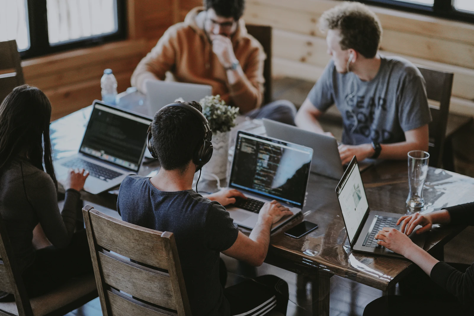 People collaborating around laptops in a shared workspace